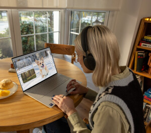 A woman seated at a table using a Dell laptop